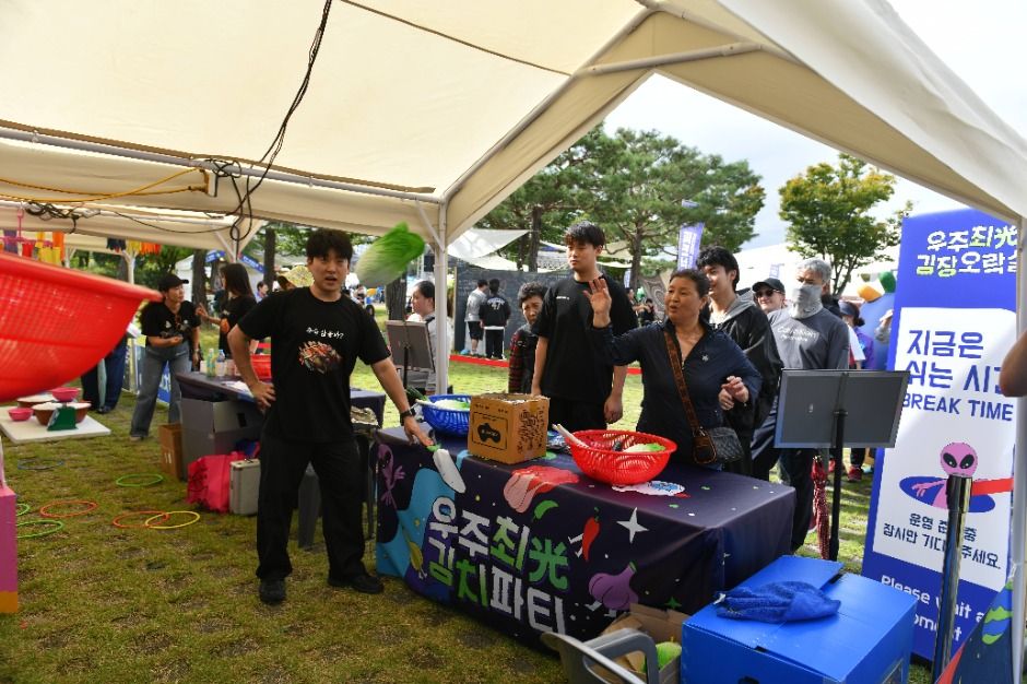 2025년 우주최광 김치파티 체험 부스에서 방문객이 게임 안내를 듣는 모습